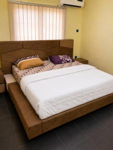 a large bed with two pillows on top of it at Kays Royal Suite in Isasi