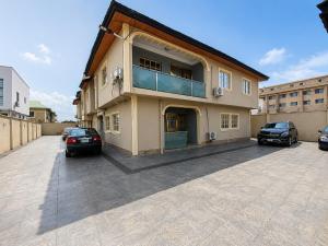 a building with two cars parked in a parking lot at Kays Royal Suite in Isasi