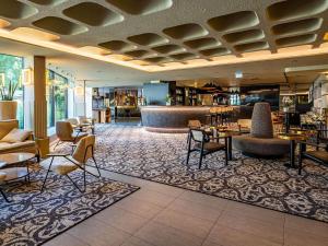a lobby of a hotel with tables and chairs at Novotel Marne La Vallée Collégien in Collégien