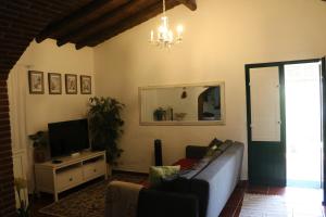 a living room with a couch and a television at C M Casa de Mares Alojamento Local in Casas Novas de Marés