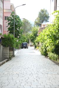 a car is driving down a cobblestone street at Prim Guest House in Këlcyrë