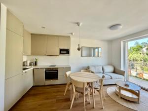 a kitchen and living room with a table and a couch at Ager Apartments Poprad in Poprad