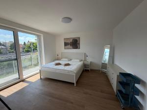 a bedroom with a bed and a large window at Ager Apartments Poprad in Poprad
