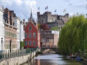 a bridge over a river with a castle in the background at Castle-grounds house with rooftop view & jacuzzi in Ghent