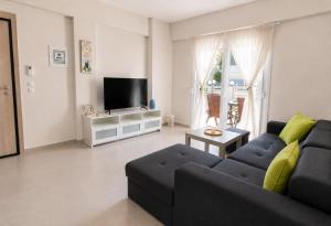 a living room with a couch and a tv at Lagonisi Apartment in Skála Nikíta