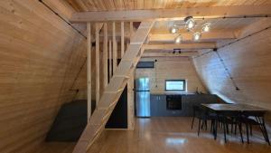 a staircase in a room with a table and a kitchen at Riverside Ghari Cottages in Oni