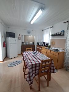 a kitchen with a table and a kitchen with a refrigerator at Casa Vale Frio in Calheta