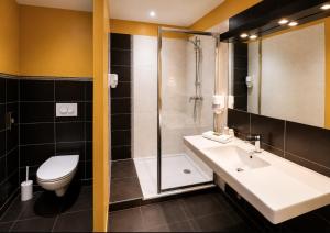 a bathroom with a sink and a shower and a toilet at Hôtel Restaurant Akena Bordeaux Sud - La Brède in La Brede +15 photos