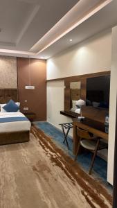 a bedroom with a bed and a desk and a television at سراة للشقق الفندقية in Al Namas +74 photos