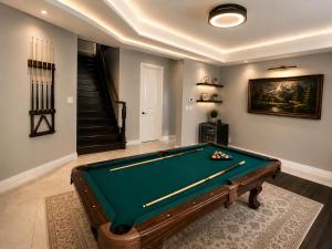 a room with a pool table and a staircase at Cozy Beautiful Home in Brampton