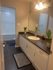 a bathroom with a sink and a mirror at Cozy Beautiful Home in Brampton
