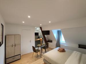 a bedroom with a bed and a table and chairs at Résidence du Palais in Nevers