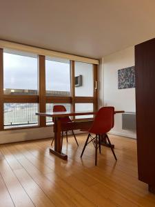 a room with a table and chairs and windows at Le Corbusier Expérience in Firminy