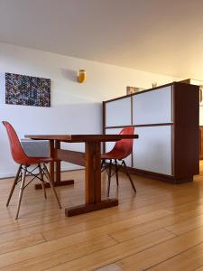 a dining room with a wooden table and chairs at Le Corbusier Expérience in Firminy