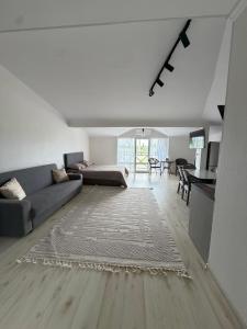 a living room with a couch and a table at Raduga West 19-9 in Koshkolʼ