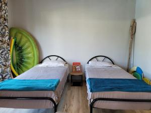 two beds in a room with a watermelon on the wall at Lazy Tilapia in Baie du Tombeau +31 photos