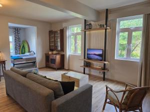 a living room with a couch and a tv at Lazy Tilapia in Baie du Tombeau