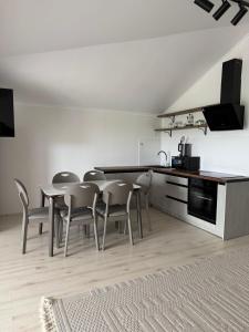 a kitchen and dining room with a table and chairs at Raduga West 19-9 in Koshkolʼ