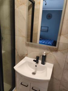 a bathroom with a white sink and a mirror at Pokoje u Renatki in Chałupy +26 photos