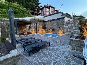 a patio with benches and a swimming pool at Gloria Holiday - Villa di Istria in Piran
