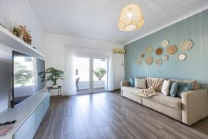 a living room with a couch and a television at T1 Morderno - Alvor in Alvor