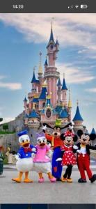a group of people posing in front of a disney castle at Disney golden house in Magny-le-Hongre
