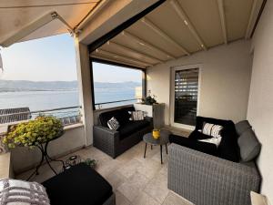 a balcony with couches and a view of the water at Apartments Salona in Trogir
