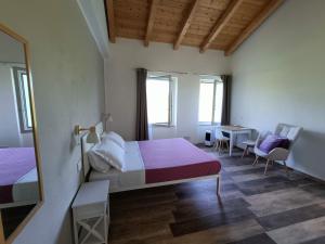a bedroom with two beds and a mirror and a table at B&B La Piccola Lepre in Acqui Terme