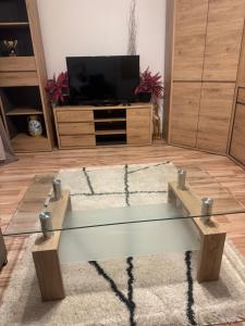 a glass coffee table in a living room with a tv at Apartament M6 w Centrum Wiela in Wiele
