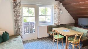 a small room with a table and chairs and a window at Appartementhaus Huber in Abersee