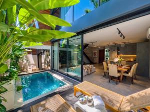 an open deck with a swimming pool and a dining room with a table at Superior Luxury Loft with Working Desk, Instagramable Pool in Kerobokan