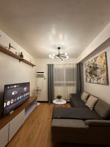 a living room with a couch and a flat screen tv at MK Suites CDO in Pontud