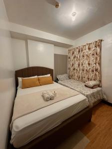 a bedroom with a large bed with two towels on it at MK Suites CDO in Pontud
