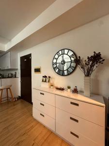 a white dresser with a clock on a wall at MK Suites CDO in Pontud