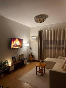 a living room with a couch and a tv at MK Suites CDO in Pontud
