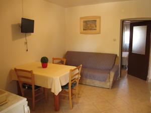 a living room with a table and a couch at Apartments Roza in Rošini