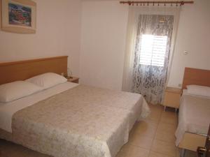 a bedroom with a bed and a window with at Apartments Roza in Rošini