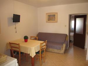 a living room with a table and a couch at Apartments Roza in Rošini