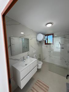 a bathroom with a sink and a toilet and a mirror at Casa vacanze Cape Rodon in Draç