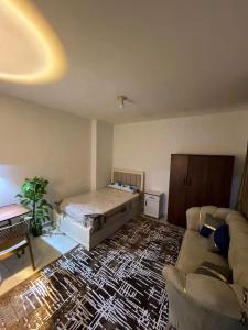 a living room with a bed and a couch at Hekmt home in Kafr al Ishārah