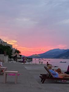 a group of people laying in lawn chairs on the beach at sunset at Mina in Krašići +7 photos