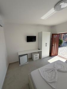 a white room with a bed and a tv at Casa vacanze Cape Rodon in Draç