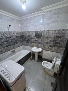 a bathroom with a tub toilet and a sink at Hekmt home in Kafr al Ishārah