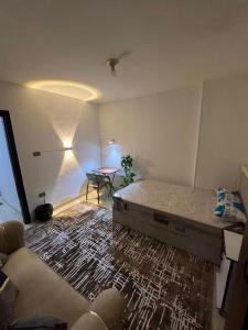 a bedroom with a bed and a table and a couch at Hekmt home in Kafr al Ishārah