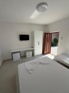 a white room with a bed and a flat screen tv at Casa vacanze Cape Rodon in Draç
