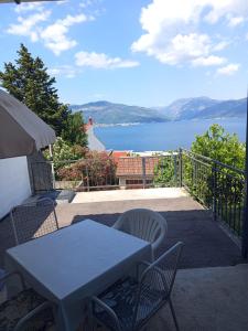 a table and chairs on a balcony with a view of the water at Mina in Krašići