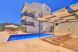 a villa with a swimming pool and a house at Apollon Apartment in Kalkan