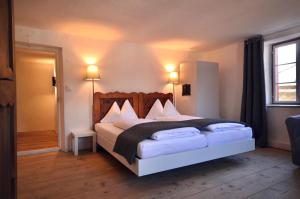 a bedroom with a large bed with white pillows at SOMMERFRISCHE TSCHENGLS Ein ganzes historisches Ferienhaus für euch in SÜDTIROL Urlaub im ruhigen Bergdorf Tschengls im Vinschgau mit Weitblick und Gartenterrasse ideal für Kleingruppen Familien mit Hund Besonders empfehlenswert im FRÜHLING und HERBST in Lasa