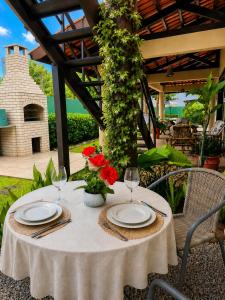 a table with plates and glasses and flowers on it at Alisios Kite Lodge in Cumbuco
