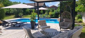 a patio with chairs and a table and an umbrella at Chambre d'hôte de Reymure in Vif